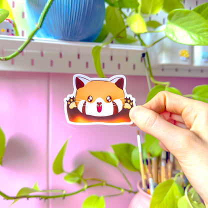 Close-up of the cheerful red panda sticker held between fingers, showing bright orange fur, tiny paws and an excited expression. Natural light highlights the smooth matte laminate and crisp printed lines. This detailed view showcases the energetic “happy mood” design, perfect for decorating journals or tech while adding a playful, positive vibe to everyday stationery and kawaii animal collections.