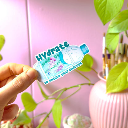 Close-up of a hand peeling and placing the jellyfish sticker onto a smooth surface near a plant to show size and flexibility. The matte laminated surface and clean die cut edges highlight the durable finish. This cute ocean animal decal applies easily to water bottles, planners, laptops and journals, making it a funny everyday hydration and mental health reminder.