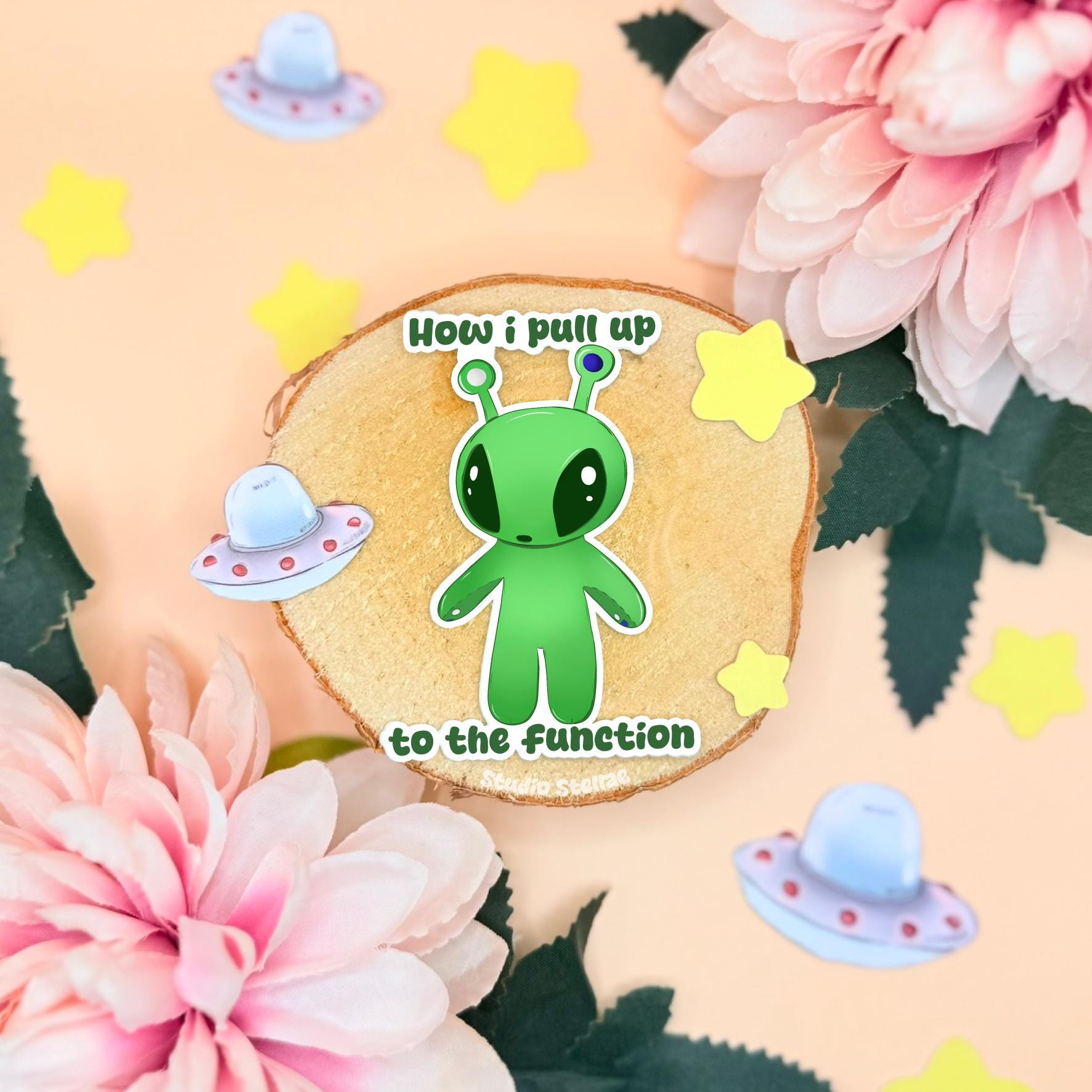 Aftonsparv Alien sticker shown in a soft pastel flat lay with pink flowers and sparkly star charms. The cute green IKEA alien plushie fan art character stands centered with a glossy matte laminated finish and bold die cut shape. This chibi alien sticker features the funny “How I Pull Up to the Function” quote and works perfectly as a laptop sticker, water bottle decal or journal decoration for stationery lovers and alien fans.